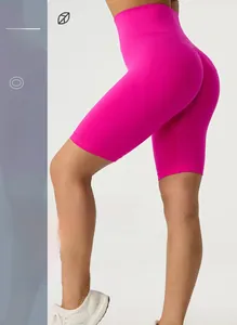 Close-up of high-waisted seamless peach yoga shorts in rose red with V-shaped lifting seam