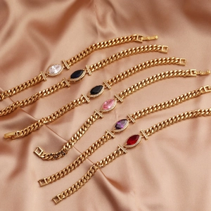 Close-up of gold plated Cuban link bracelets with marquise-cut colorful zircons