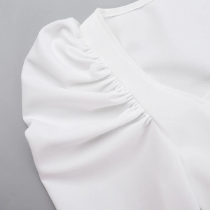 Détail des manches bouffantes blanches et coutures du col en V sur robe élégante