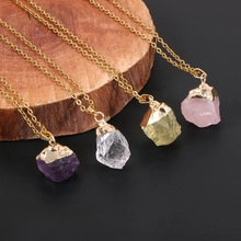 Detail of colorful raw natural crystals with gold-plated edges on golden necklaces