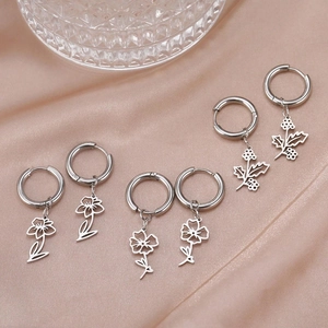 Elegant stainless steel flower earrings displayed on pink silk fabric background