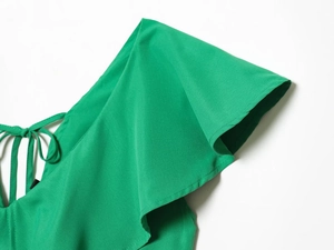 Detail of bright green romper showing ruffle sleeves and tie neck with smooth fabric