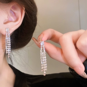 Close-up of sparkling rhinestone tassel drop earrings on model with elegant jewelry design