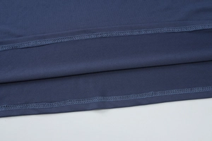 Detailed macro view showing the precise double-needle hem stitching on navy blue knit dress