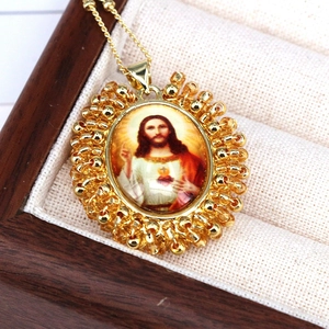 Close-up of golden Sacred Heart of Jesus oval pendant with colorful beads and chain