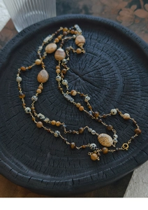 Detailed macro view of 14K gold plated spheres and natural picture stone beads on necklace