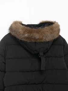 Détail de la fourrure brune sur la capuche d'une parka noire matelassée pour femme
