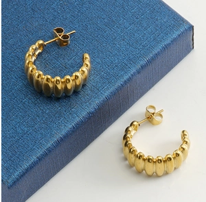 Vue détaillée des boucles d'oreilles croissant en acier doré 18k avec texture striée