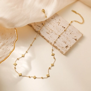 18K gold plated stainless steel necklace with star pendants and beads on beige satin
