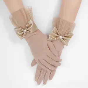 Detail of champagne tulle gloves with ruffled mesh cuffs and elegant satin bows
