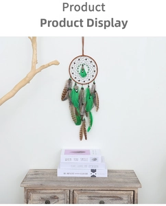Detailed view of bohemian dream catcher featuring green feathers and brown woven beads