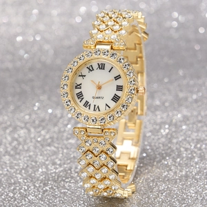 Detail of gold women's quartz watch with Roman numerals and rhinestone-encrusted metal band