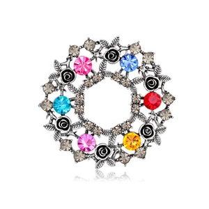 Detailed close-up of a floral silver brooch with colorful rhinestones and black roses