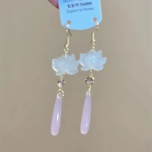 Detailed shot of 925 silver lotus flower drop earrings with pink water drop pendants