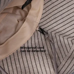 Detail view of the detachable windproof rope and hook on the striped cotton sun hat