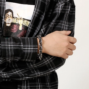Detail of vintage silver titanium steel chain bracelet worn by male model in street style