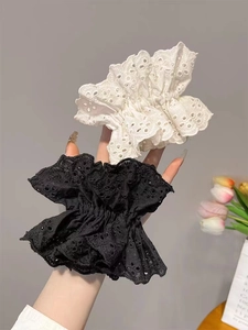 Close-up of white and black lace hollow hair scrunchies with elastic band texture