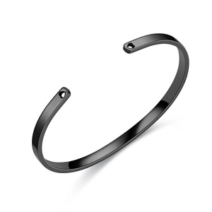 Close-up of a minimalist black titanium steel cuff bracelet with heart-shaped holes