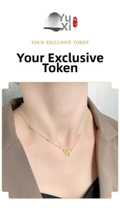 Close-up of golden bow pendant with star link chain on model wearing a brown blazer