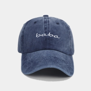 Detail einer blauen gewaschenen Baumwoll-Basecap mit weißer baba-Stickerei und Vintage-Textur