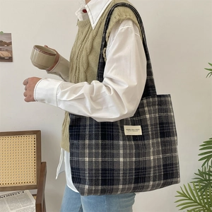 Close-up of vintage plaid tote bag with wide shoulder strap for autumn commute