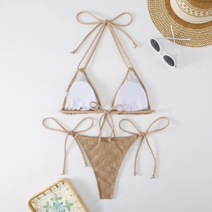Detail shot of khaki textured halter bikini set with straw hat and beach accessories