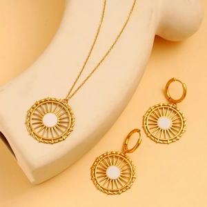 Détail de l'ensemble collier et boucles d'oreilles roue solaire dorée sur mannequin