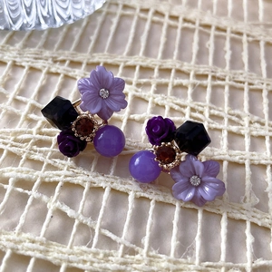 Detailed view of purple flower earrings with crystal beads and rhinestones decoration