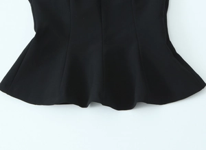 Detail of black elastic tank top showing the pleated ruffled hem and smooth stitching