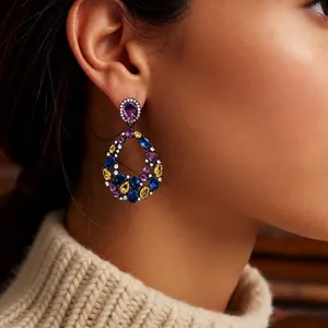 Vintage palace style teardrop earrings with colorful zircon stones worn by a model