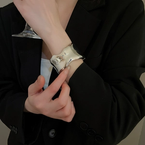 Detailed view of silver irregular wavy cuff bracelet with a polished mirror finish surface