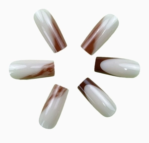 Detail showing long coffin shape press-on nails with brown marble and French tip design