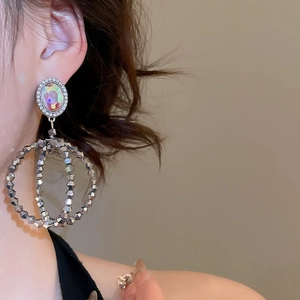 Gros plan de boucles d'oreilles pendantes rondes en argent avec cristaux sur un mannequin