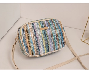 Close-up of rainbow woven crossbody bag with beige faux leather trim and gold hardware