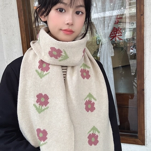 Detail of soft cream knit scarf featuring delicate pink flower and green leaf patterns