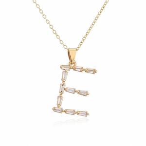 Macro shot of 18K gold plated letter E pendant with cubic zirconia on white background