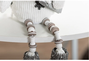 Macro detail of Christmas gnome legs with white corduroy and wooden bead accents