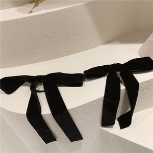 Close-up of black velvet bow hair accessories on minimalist geometric steps