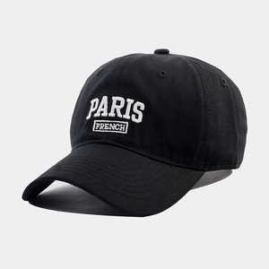 Detailed macro view of white 3D embroidery showing PARIS FRENCH on a black cotton baseball cap