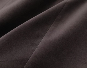 Macro shot of charcoal grey velvet dress fabric showing soft texture and pleated details