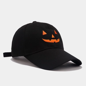 Close-up of orange pumpkin embroidery on a black cotton baseball cap for Halloween