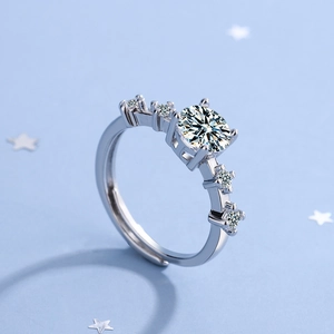 Adjustable silver ring with round zirconia and side stones on starry blue background
