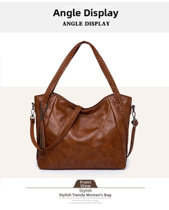 Front view of brown soft leather tote bag featuring woven handles and tassel detail