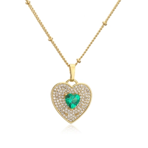 Macro detail of 18K gold plated heart necklace with green zircon and micro pavé stones