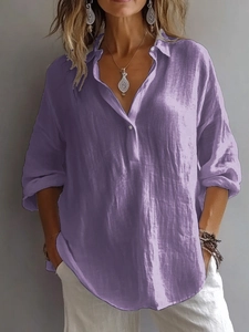 Détail d'une chemise violette en lin montrant le col en V, les boutons et le tissu