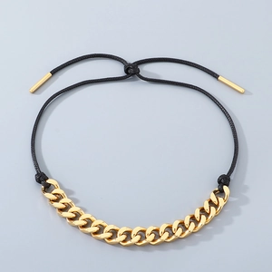 Detail view of gold Cuban chain and black woven rope necklace with adjustable slider clasp