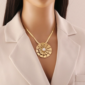 Golden snake chain necklace with large round fan pendant and pearl on female model neck