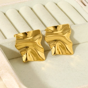 Macro detail of gold-plated 316L stainless steel crinkled square earrings in a jewelry box