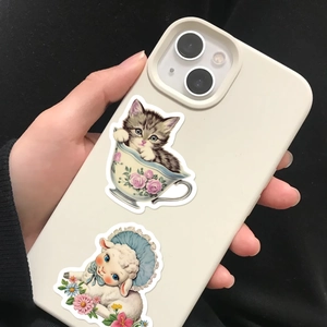 Close-up of waterproof vintage cat and sheep stickers on a white smartphone case