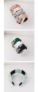 Detail view of knotted fabric headbands in various colors decorated with faux pearls